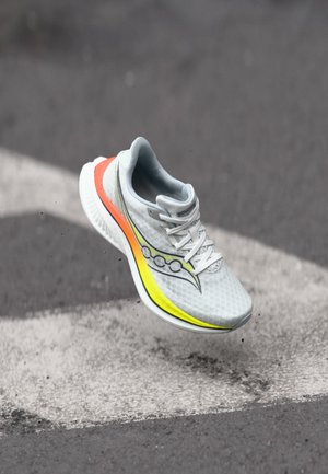 Light gray running shoe with a mesh upper, featuring a colorful gradient stripe in yellow, orange, and black on the side, and white sole.