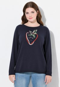 Navy-blauer Pullover mit langen Ärmeln, der ein großes Erdbeer-Motiv in Rot, Grün und Weiß zeigt. Weicher Stoff mit geripptem Rundhalsausschnitt und Saum.