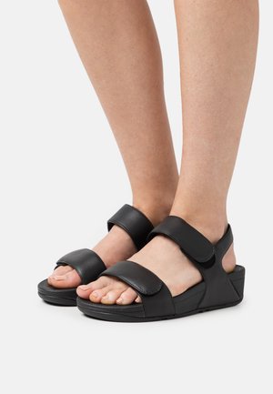Zwarte sandalen met twee brede, verstelbare banden van synthetisch materiaal, voorzien van een gestructureerde voetbed en een lage wigzool.