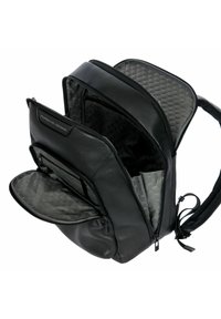 Zaino in pelle nera con interno grigio a motivo esagonale, più scomparti con cerniera e spallacci imbottiti.