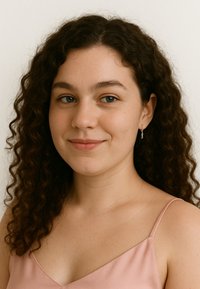 Porträtt av en person med lockigt brunt hår, klädd i en rosa satinlinne och silverfärgade hoopörhängen, mot en neutral bakgrund.