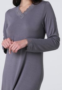 Abito grigio a maniche lunghe con scollatura a V e dettagli in pizzo sul collo e sui polsi. Tessuto morbido e liscio con una vestibilità comoda.