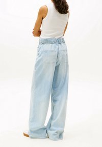 Pantalones de pierna ancha a rayas azul claro con una cintura elástica y dos bolsillos traseros, fabricados en una suave tela tipo algodón.