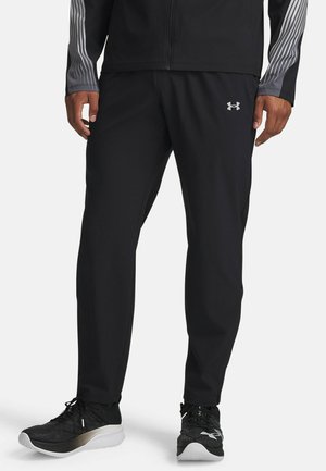 Black athletic pants made from lightweight material, featuring a tapered design and an elastic waistband. Accented with a small logo on the front.