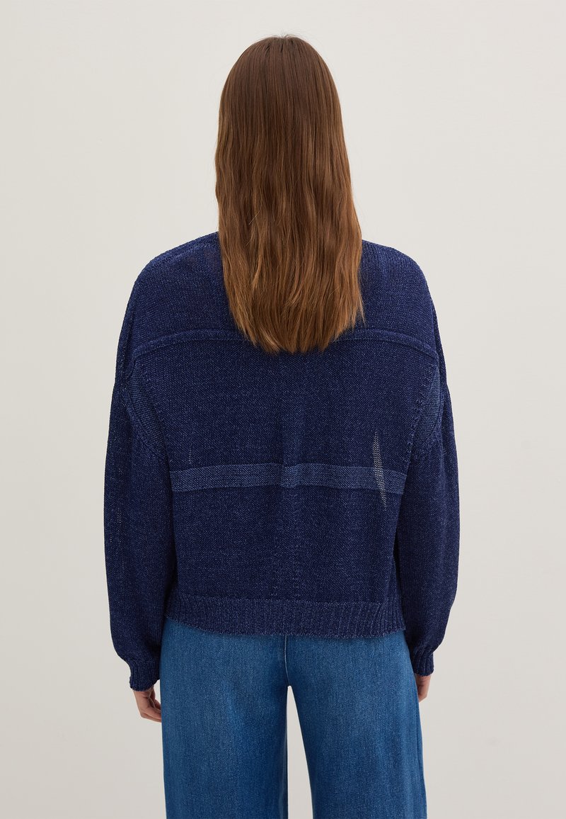 Dunkelblaues, übergroßes Strickpullover mit einem strukturierten Muster und gerippten Bündchen. Hat ein gestreiftes Detail entlang des Rückens und einen lässigen Schnitt.