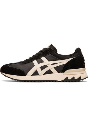 Sort-hvid lavtop sneaker med ruskind og stofdetaljer, hvide sidelister, sorte snørebånd og en struktureret beige sål.