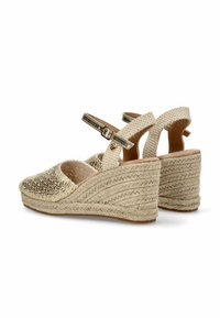 Sandalias de cuña beige con detalle de yute trenzado, parte superior texturizada y correa ajustable con hebilla metálica.