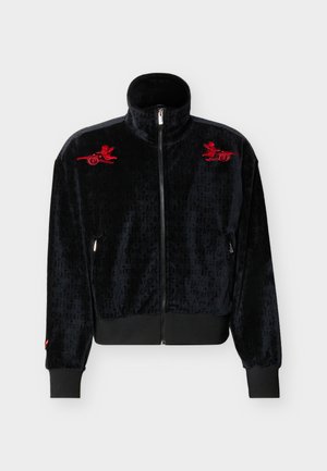 Chaqueta negra de terciopelo con cremallera, cuello alto, puños acanalados, tela con patrón sutil y querubines rojos bordados en cada hombro.