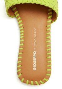 Sandalo con fascia intrecciata verde e suola beige. Presenta cuciture in un vivace verde a contrasto e il nome del marchio stampato "GIOSEPPO".