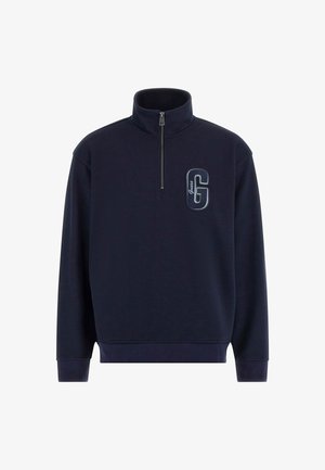 Sweatshirt bleu marin cu fermoar la jumătate, dintr-un material texturat, având un logo 'G' brodat proeminent pe piept și manșete ribbate.