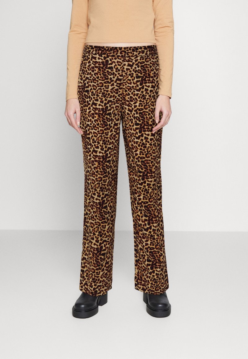 Leopardmönstrade, högmidjade byxor i brunt och beige, gjorda av textil med struktur. Raka ben; matchade med svarta platåskor.