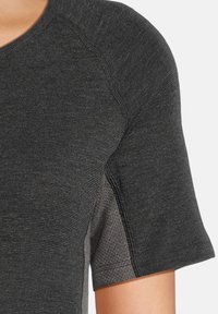 Mørkegrå atletisk t-shirt med korte ærmer, tekstureret stof, farveblanding på siderne og synlig syning.