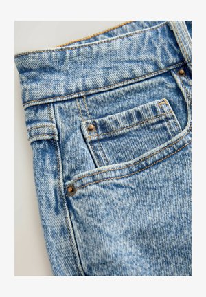 Svetlomodré denimové džínsy s zadným vreckom, kontrastným žltým stehom a textúrovaným povrchom so subtilnými opotrebovanými vzormi.