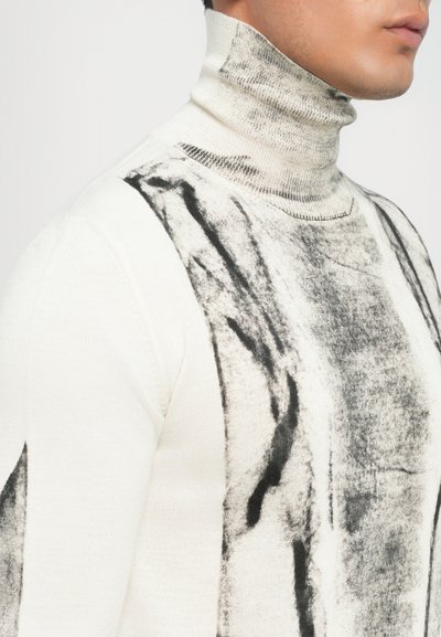 Λευκό πουλόβερ με λαιμόκοψη και μαύρα αφηρημένα σχέδια, με εφαρμοστή σχεδίαση και υφασμάτινη πλέξη.