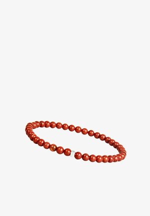 Dehnbare Armbänder mit runden roten Perlen und einer einzelnen kleinen weißen Perle auf einem weißen Hintergrund.