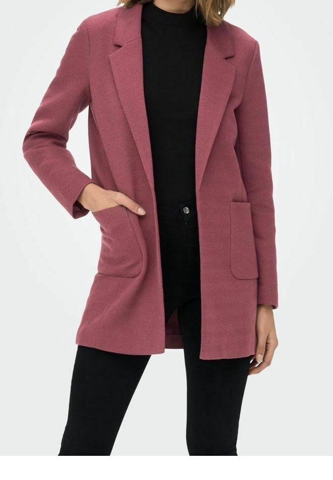 Roze visgraat blazer met een getailleerde pasvorm, pieklapels, twee zijzakken en lange mouwen. Gepaard met een zwarte top en broek.