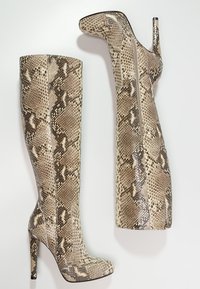 Knee-high stiletto boots made of textured faux snake skin. Beige and brown mottled pattern with a side zipper. Pointed toe design.