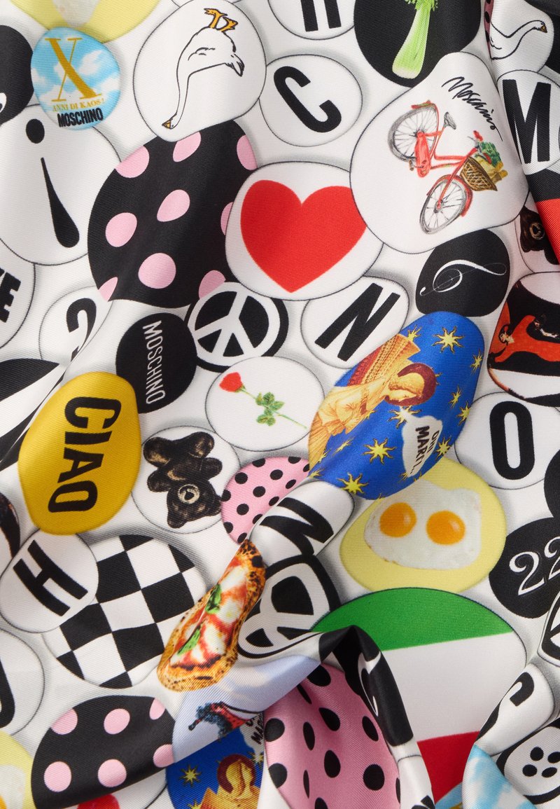 Buntes Stoffmuster mit verschiedenen gemusterten Kreisen, darunter schwarze und pinke Polka-Dots, Text sowie Bilder wie ein Fahrrad, Pizza und Herzen.