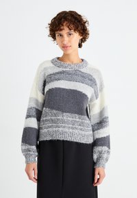 Maglione a righe grigie e bianche in maglia con scollo rotondo, maniche lunghe, motivo testurizzato e orlo corto. Tessuto morbido e peloso.