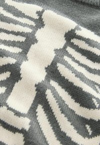 Grå sweater med et strikket design, der ligner ribben i hvid, med en blød tekstur og medium tykkelse.