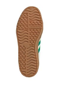Gummisula till sneakers med ett mönstrat mönster, med en central "adidas"-logotyp. Färgen är ljusbrun med en vågig och diamantformad design.