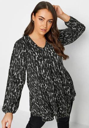 Zwarte blouse met lange mouwen en witte abstracte print, V-hals en gathered mouwen. Lichtgewicht stof met een vloeiende, relaxed fit.