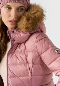 Roze pufferjack met een afneembare nep-bont capuchon, gewatteerd ontwerp, ritssluiting aan de voorkant en zwarte drukknoopjes met logo accent.