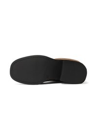 Suola in gomma nera con grip texture, caratterizzata da una forma arrotondata e un design minimale, parzialmente coperta da un tomaia in pelle marrone.