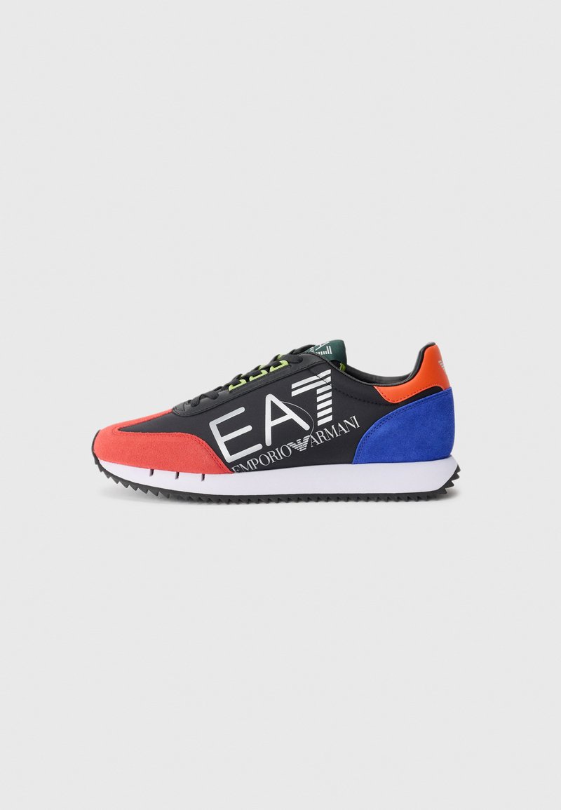 Sort sneakers med røde og blå accenter, struktureret ruskind og glat materiale, med et fremtrædende hvidt logo, grøn snørebånd og en hvid sål.