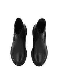 Botas de tobillo de cuero negro con paneles laterales elásticos, punta redonda y costuras en contraste alrededor de la suela. Textura suave y diseño simple.