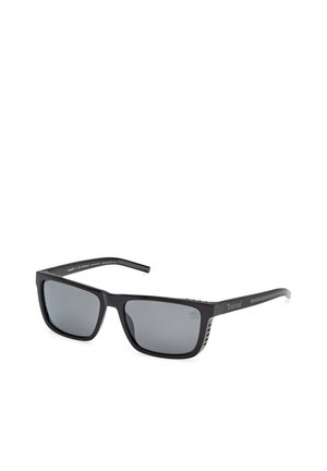 Gafas de sol rectangulares negras Timberland con lentes tintadas oscuras, con una marca sutil en las patillas y una montura con acabado mate.