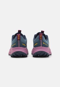 Chaussures de trail en bleu et rose, avec un dessus texturé, marquage Gore-Tex et des lacets contrastés. Semelle en caoutchouc pour une bonne adhérence.