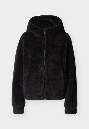 Svart, lodden hettejakke med glidelås, lange ermer og en myk, plyssaktig tekstur, vist flatt på en lys bakgrunn.