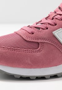 Růžové tenisky s kombinací semiše a síťoviny, texturovaný svršek, šedé akcenty a gumová podrážka s viditelným vzorem.