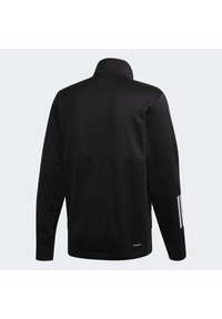 Veste noire à manches longues avec col haut, dos sans couture et trois bandes blanches sur l'avant-bras droit, conçue pour la circulation de l'air (Aeroready).