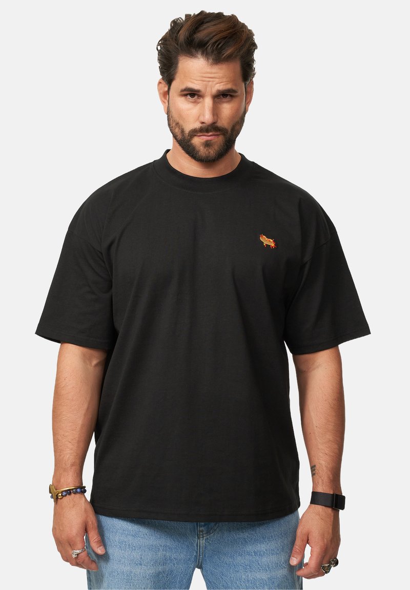 Black cotton t-shirt with short sleeves, a crew neckline, and a small embroidered design in red and orange on the chest.
