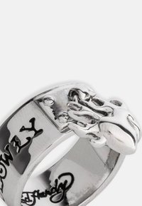 Sølvmetallring med et detaljert klo-design. Ringen har den graverte teksten "LOWLY" og er polert for en blank finish.