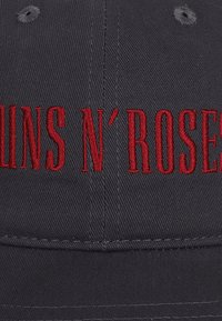 Cappellino da baseball nero con ricamo "GUNS N' ROSES" in rosso. Presenta una corona strutturata e una visiera curva, realizzato in tessuto resistente.
