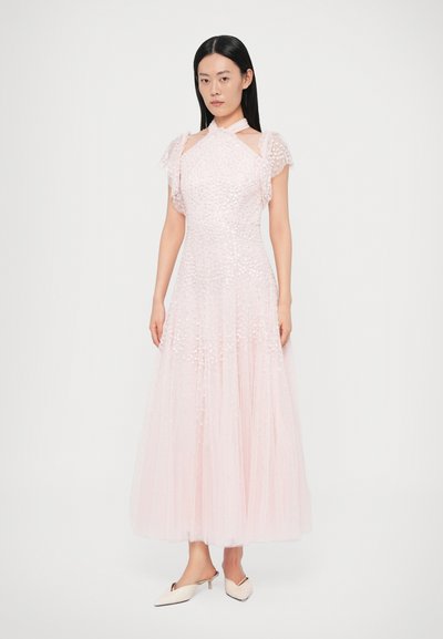 Világos rózsaszín, földig érő ruha rövid fodros ujjakkal, díszített felsőrésszel, áttetsző rétegekkel és nyitott váll kialakítással. Fehér magas sarkú papucsok.