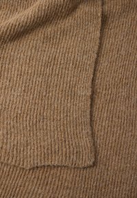 Ύφασμα με μείγμα κασμίρι σε ζεστή καφέ απόχρωση, με ραβδωτή υφή. Μαλακή, ελαφρώς χνουδωτή επιφάνεια με ίσια ραφή στο τελείωμα.