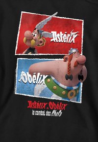 Black T-shirt featuring colorful graphics of the characters Asterix and Obelix against red and blue backgrounds with distressed edges.