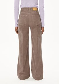 Bruine corduroy wijdvallende broek met voor- en achterzakken, een hoge taille en een zichtbaar label op de achterste tailleband.