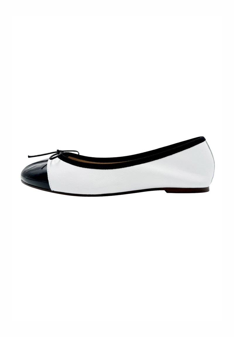 Ballet flat in pelle bianca con punta in vernice nera. Presenta un bordo nero e un dettaglio a fiocco sulla parte anteriore. Design con suola piatta.