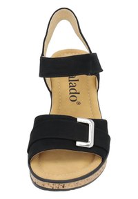 Sandalia negra con correas anchas y hebilla plateada, suela de corcho y forro beige. Diseño de talón abierto con textura suave.