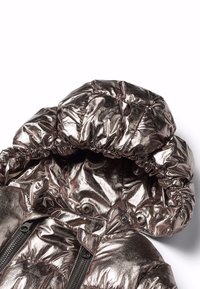 Metallic puffer-jacka med huva, rynkat tyg runt kanterna, glänsande yta, två svarta fickor med dragkedja och tryckknappsstängning.