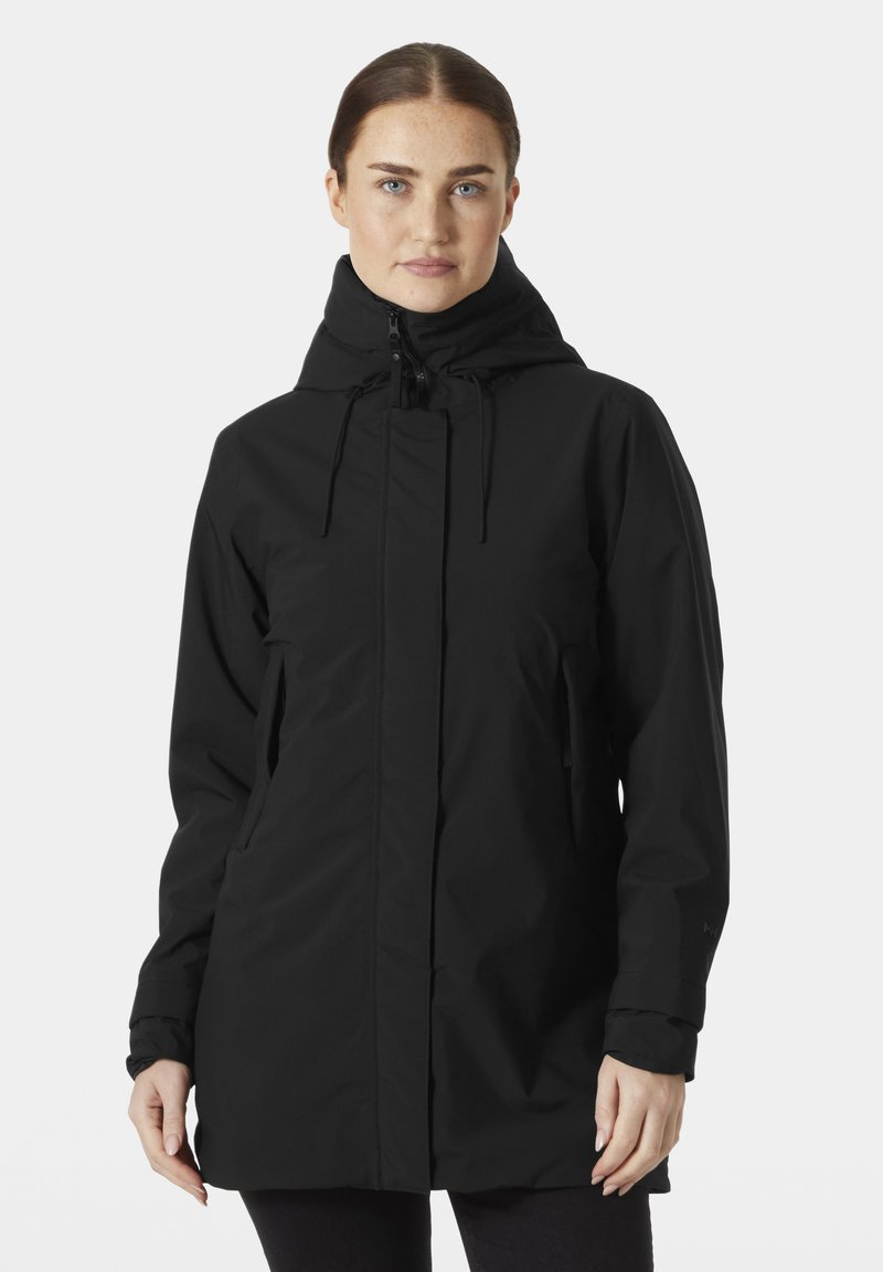 Chaqueta negra impermeable con cuello alto, cordones ajustables, dos bolsillos laterales y mangas largas. Textura suave y diseño sencillo.