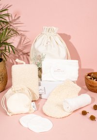 Natuurlijke schoonmaakset van katoen en bamboe, met een trekkoordzak, sponzen, doeken en herbruikbare pads in crèmekleurige en beige tinten.