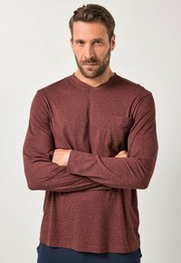 Camisa de manga larga con cuello en V en color granate con un sutil patrón texturizado, que presenta un bolsillo en el pecho y un corte relajado.