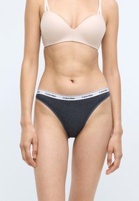 Szare bawełniane majtki z białym elastycznym pasem ze logo "Calvin Klein". Projekt ma klasyczny krój bikini z gładkimi szwami.