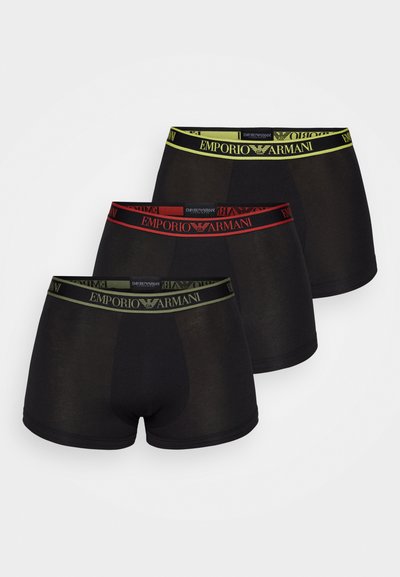 Tre paia di boxer neri presentano fasce elastiche brandizzate in rosso, verde e giallo, con una texture liscia e un design aderente.